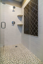 Bathroom features Shower wall field tile featured is a larger subway style Italian ceramic. Shower inset is a glass tile Moroccan pattern. Shower floor is a Turkish marble mosiac tile.