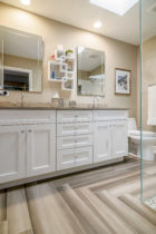 Bathroom features White cabinets with Caesarstone countertops. Italian Porcelain tile set in a herringbone pattern.