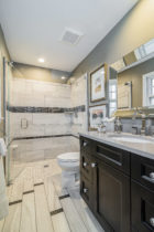 Bathroom features Flat Panel cherry onyz cabinets with Casearstone countertops and tile floor.