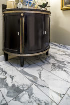 Bathroom features Italian Statuario Venato 12x24 polished marble, set in a brick pattern.