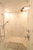 Shower Walls are 12x24 Marmi Statuario Pocelain Tile with a Herringbone Inset. Shower seat is Silver Shadow Marble.